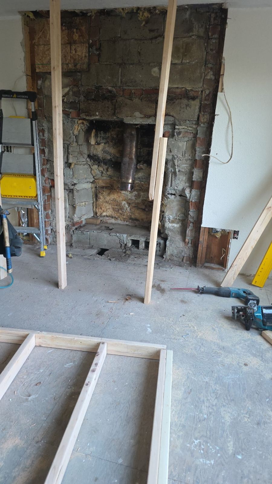 Old masonry chimney exposed and framed around during demolition