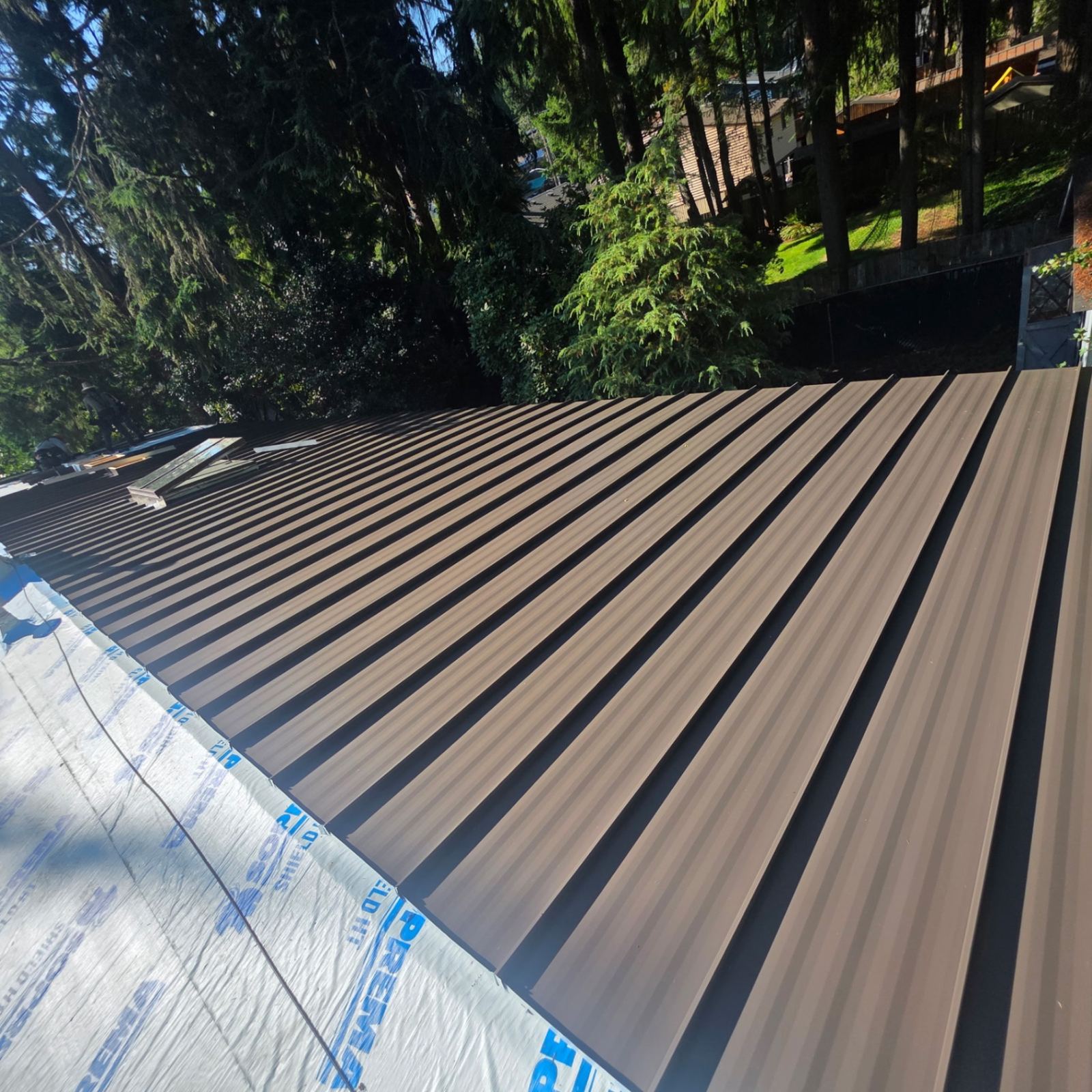 Standing seam metal roof panels installed over a home