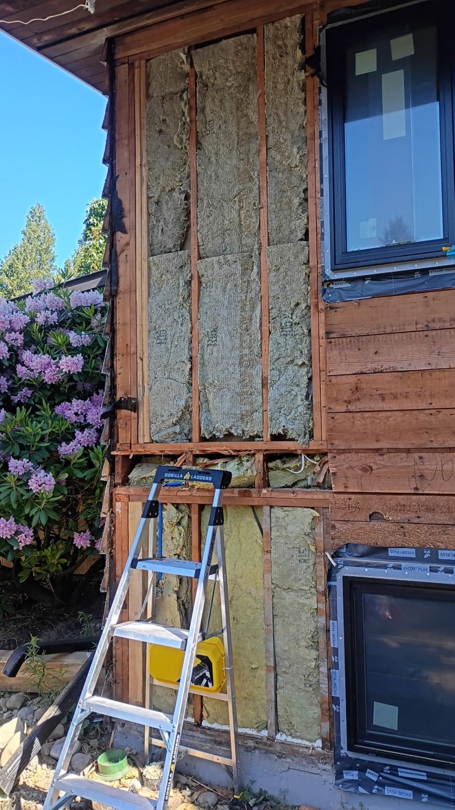 Exterior wall framing exposed with new windows flashed and installed